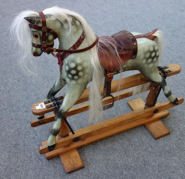 A Victorian style dapple grey rocking horse, with leather saddlery, on a pine and wrought iron swing frame base, 74cm high.