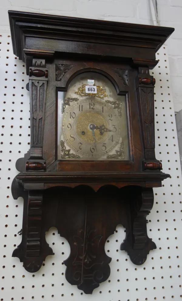 An English stained pine wall clock, late 19th century, with a stepped pediment over a silvered dial and architectural carved case, enclosing a two tra