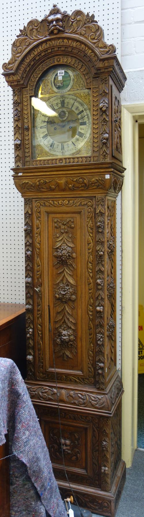 A carved oak longcase clock, 19th century, the brass dial with moonphase aperture painted with a fully rigged ship and titled 'The Royal George', with