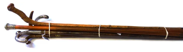 An early 20th century hazel walking stick, with a white metal handle, 83cm long, an unusual horn walking stick, late 19th century, of naturalistic for