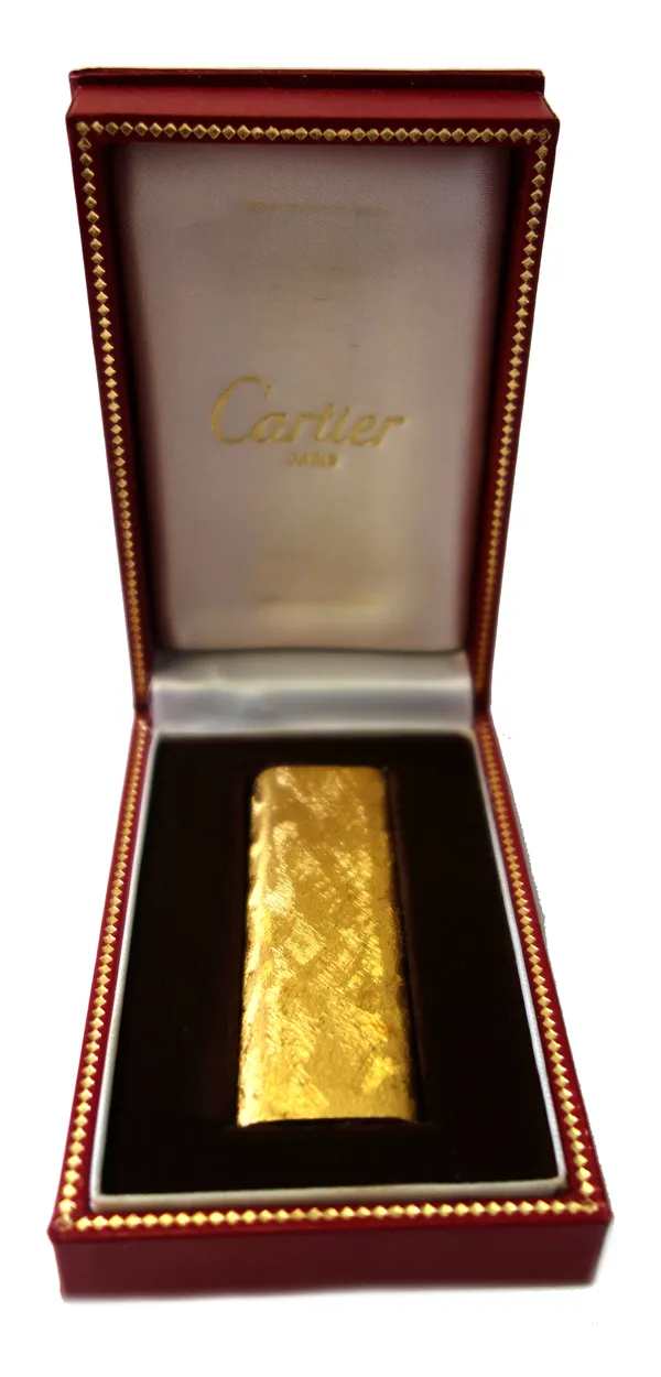 Cartier; a gold plated lighter, with textured finish, signed, numbered 177350, 7cm long, cased.