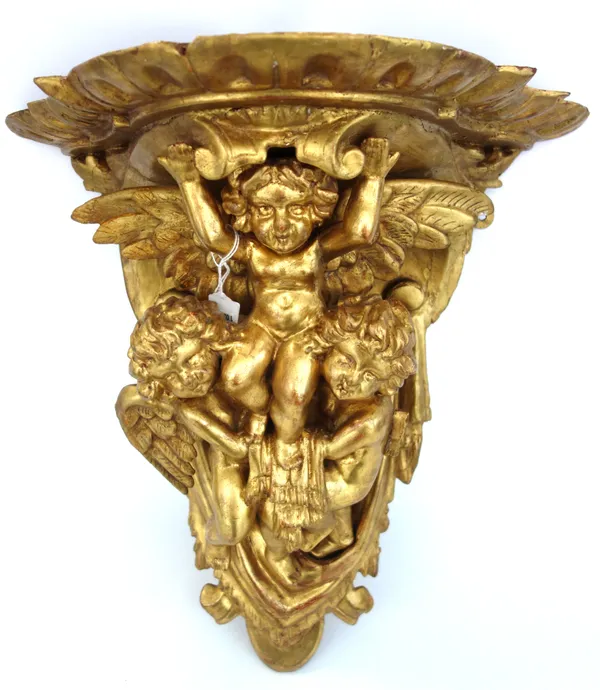 A giltwood carved figural wall bracket, 19th century, the shaped top supported by three putti against a swagged backplate (a.f), 45cm high.