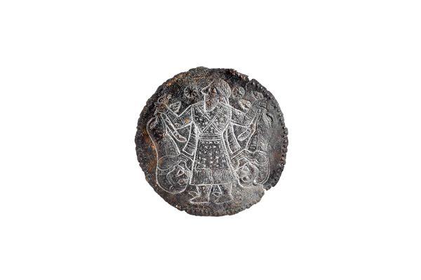 A circular iron medallion, possibly Ancient, depicting a Mesopotamian figure holding two lions aloft (a.f), 11.5cm diameter.  Illustrated