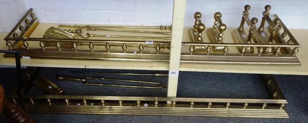 Two Victorian style brass fenders, each with pillared supports and stepped kerb, 144cm long, a matching pair of andirons, three matching brass fire to