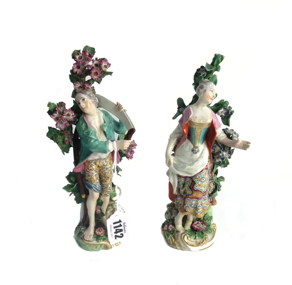 A pair of Chelsea gold anchor figures of harvesters, circa 1765, modelled as a gallant and companion standing before a flowering tree, the young man h