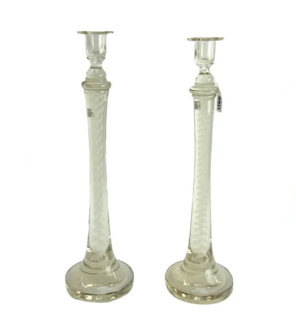 A pair of glass candlesticks, early 20th century, with inclusions to the tapering stem on a wide spreading circular foot (a.f.). 49cm high (2).