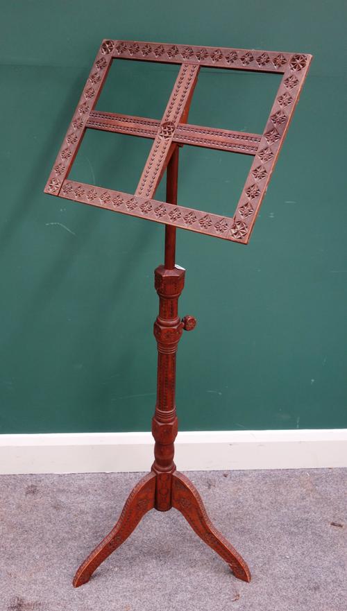A 19th century carved sandalwood adjustable music stand on tripod base, 49cm wide x 129cm high, (extending to 172cm high).