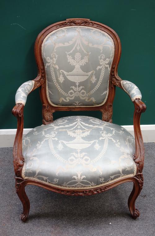 A Louis XV carved beech open arm fauteuil, on scroll supports, 65cm wide x 94cm high.
