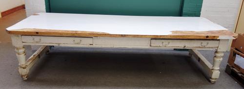 A large Victorian white painted pine country house scullery table, with four frieze drawers, on turned supports, 117cm wide x 300cm long.