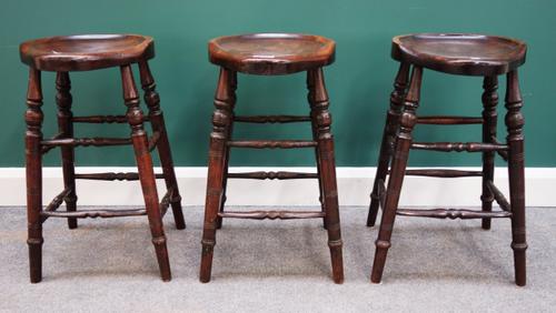 A set of three 19th century and later stained beech stools on turned supports, 40cm wide x 65cm high.