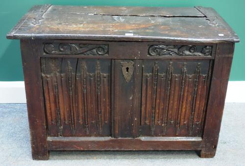 An early 17th century carved oak coffer with double linen fold panel front, 97cm wide x 66cm high.