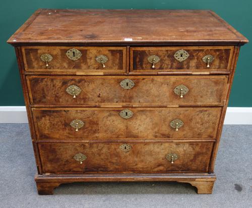 An early 18th century figured walnut chest of two short and three long graduated drawers, on bracket feet, 101cm wide x 91cm high.