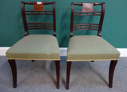 A set of six early 19th century mahogany dining chairs, with turned crest and ball mounted waist rail, on sabre supports (6).
