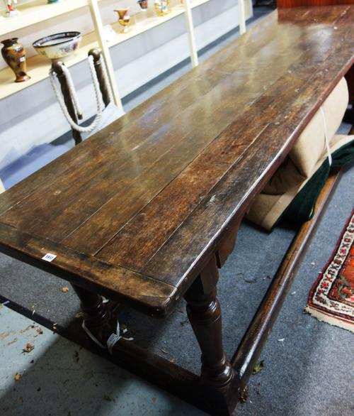 A 17th century and later oak refectory dining table, the cleated plank top on four baluster turned supports united by perimeter stretcher, 79cm wide x
