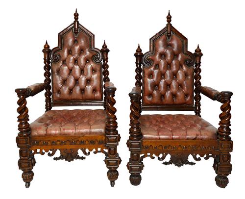 A pair of Victorian Gothic Revival rosewood framed leather upholstered open armchairs, on barley-twist supports, 71cm wide x 128cm high.  Illustrated