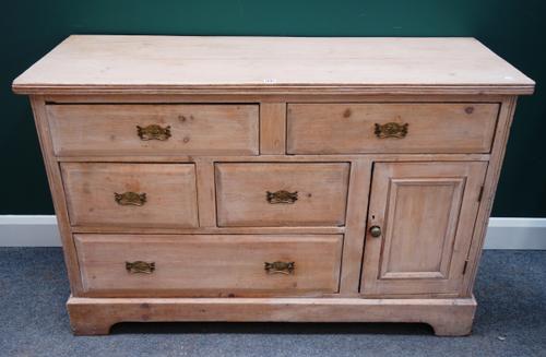 An early 19th century pine dresser base, with five various drawers and cupboard, on bracket feet, 134cm wide x 88cm high.