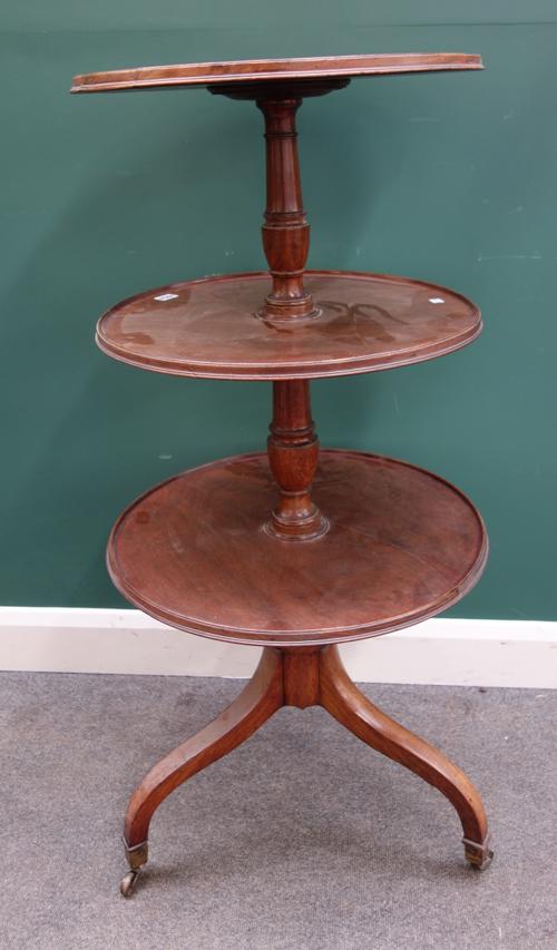 A Regency mahogany graduated circular three tier dumb waiter, on tripod base, 57cm wide x 117cm high.
