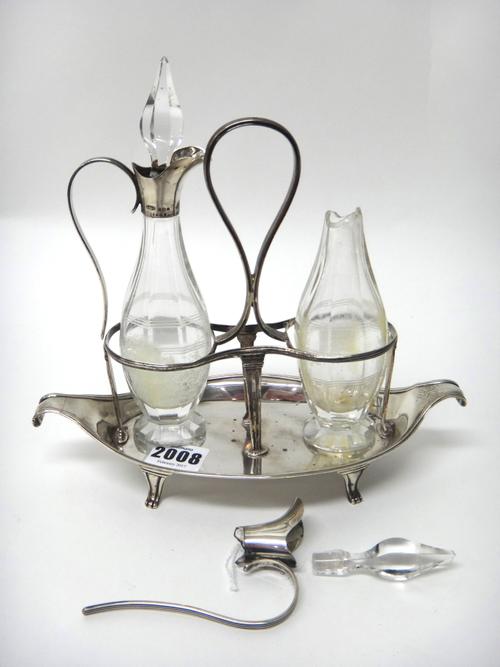 A George III silver twin bottle oil and vinegar condiment stand, of boat shaped form, with a loop shaped handle, raised on four feet, London 1794, wei