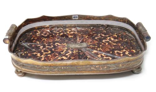 A silver plated curved rectangular twin handled gallery tray, the centre with an imitation tortoiseshell lining, the gallery decorated with a gadroone