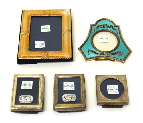 A silver and pale blue enamel mounted triangular shaped strut back photograph frame, having a circular aperture and with ribbon motifs, a silver gilt