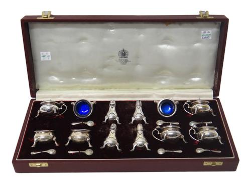 A silver twelve piece condiment set, comprising; four mustard pots, four salts and four pepperettes, each raised on three feet, with seven condiment s