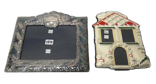 A silver mounted shaped rectangular photograph frame, having floral and scroll embossed decoration and with a vacant cartouche at the top and another