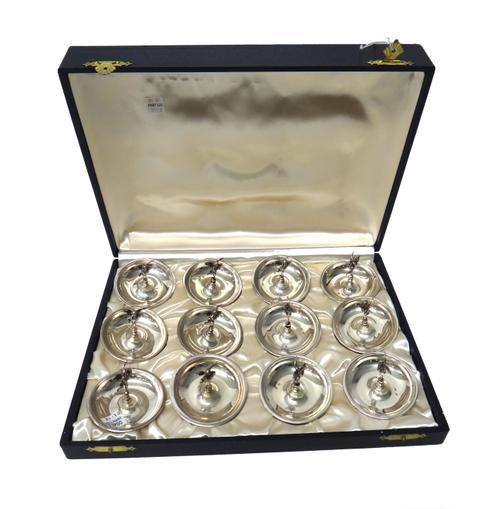 A set of twelve dishes, each of circular form, with a central standing cherub handle, detailed 800, with a fitted case, combined weight 325 gms.