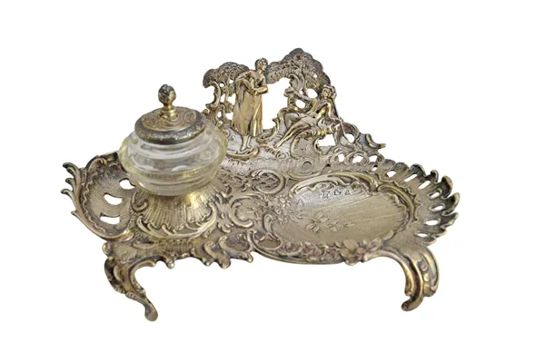 A Victorian silver inkstand, decorated with a courting couple in a landscape, otherwise with foliate sprays and raised on scrolling feet, import mark