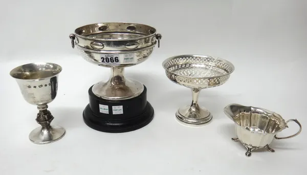 Silver, comprising; a twin handled trophy cup, presentation inscribed with a wooden stand, a milk jug, raised on four feet, Sheffield 1904, a sweetmea