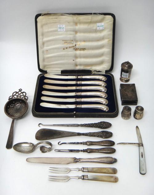 An Oriental tea strainer, a matchbox slide, and mostly silver mounted items, comprising; a button hook, a shoe horn, two implements, three condiments,