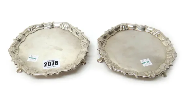 A pair of George II silver waiters, each of shaped circular form, decorated with a pie-crust rim and raised on three hoof shaped feet, diameter 15.5cm