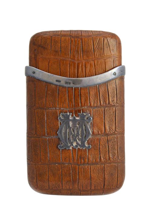A Victorian silver mounted leather crocodile effect sliding cigar case, the front applied with a monogram, London 1887.   Illustrated
