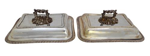 A pair of silver shaped rectangular lidded entree dishes, each decorated with gadrooned rims and with detachable handles, one handle Sheffield 1903, o
