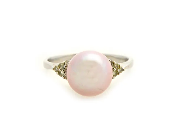 A white gold, cultured pearl and diamond ring, mounted with the large pink tinted cultured pearl at the centre, between diamond set triangular shaped