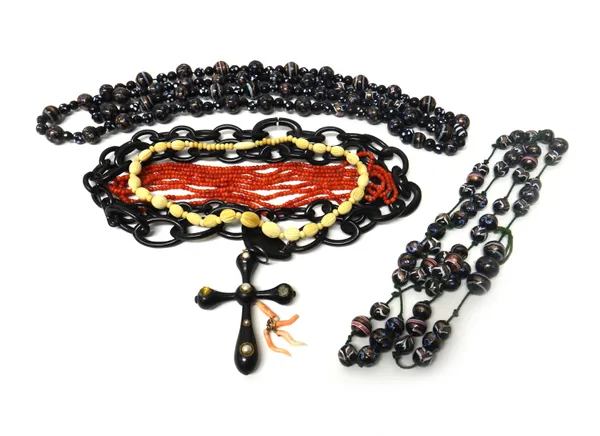 Two multicoloured glass bead necklaces, probably Venetian, a long single row necklace of coral beads, a carved bone necklace, a Victorian black pendan