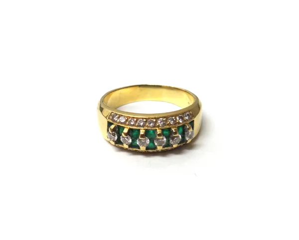 A gold, diamond and emerald ring, mounted with a row of six circular cut diamonds at the centre, above rows of pairs of square cut emeralds, between c