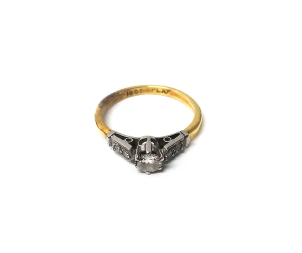 A gold and platinum ring, claw set with the principal circular cut diamond at the centre, between diamond set two stone shoulders, detailed 18 CT PLAT