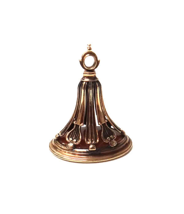 A cornelian set pendant fob seal, the mount of tapered fluted form, with lyre motifs, the cornelian seal engraved with a shield and crest motif, circa