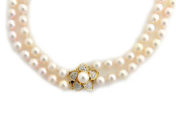 A two row necklace of uniform cultured pearls, on a gold, diamond and cultured pearl set clasp, designed as a flowerhead, detailed 14 K 585, length ex