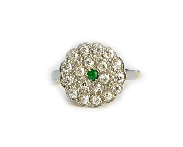 A gold and platinum, emerald and diamond set shaped circular cluster ring, mounted with the circular cut emerald at the centre within a two row surrou