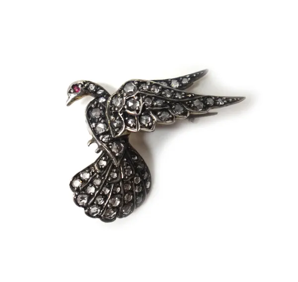 A rose diamond set brooch, designed as a bird in flight, with a ruby set eye.