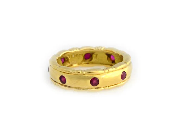 A Theo Fennell 18ct gold and ruby set eternity ring, mounted with circular cut rubies between decorated sides, ring size J, gross weight 6.5gms, with