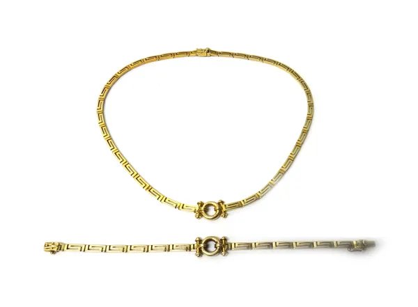 A gold collar necklace, in a curved Greek key pattern link design, with a circular and twin bar motif at the front, on a snap clasp, with a foldover s