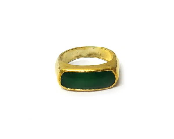 A gold and jade set single stone ring, mounted with a curved panel shaped jade, detailed 9999, ring size R and a half.