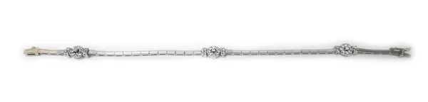 A white gold and colourless gem set bracelet, in a bar link design, spaced with three cluster divisions at intervals, on a snap clasp, detailed 14 K,