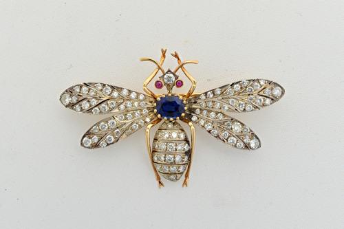 A sapphire, diamond and ruby brooch, designed as an insect with outspread wings, mounted with the oval cut sapphire to the centre, cabochon ruby set e