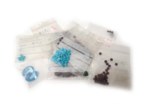 A quantity of unmounted gemstones and pastes, including, garnets, turquoise and two oval pale blue pastes.