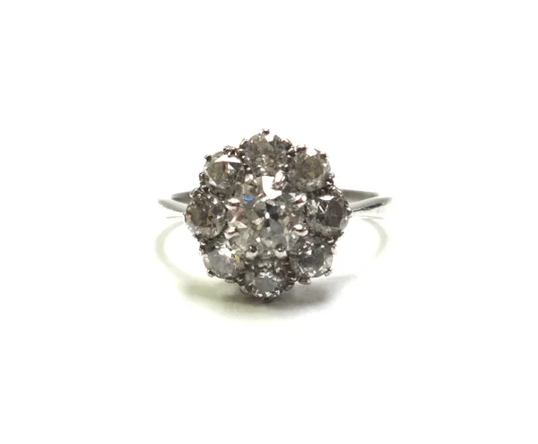 A diamond set nine stone cluster ring, claw set with the principal cushion shaped diamond at the centre in a surround of eight smaller cushion shaped