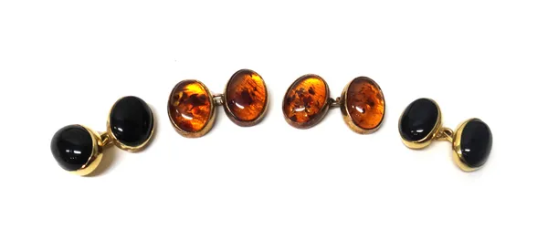 A pair of 9ct gold mounted black onyx set oval dress cufflinks and a pair of silver gilt mounted amber set oval dress cufflinks, London 1986, (2).