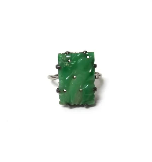 A carved jade ring, in a rectangular design, carved and pierced with fruit, (the shank somewhat distorted), with a case.